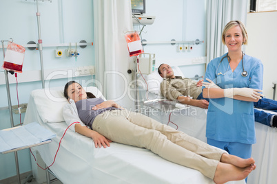 Two transfused patients next to a nurse