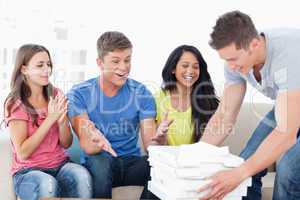Friends celebrating as one guy brings pizza to them