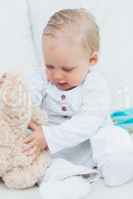 Baby touching a teddy bear
