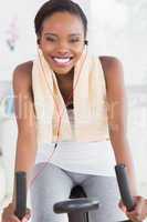 Black woman on an exercise bike listening music