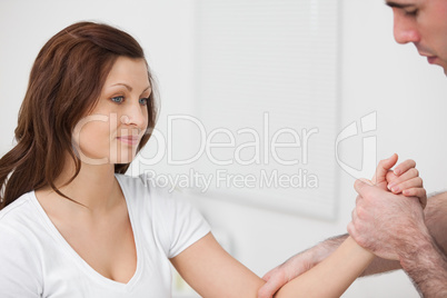 Woman sitting while a man examine her arm