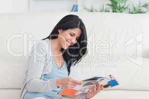 Smiling woman sitting as she reads a magazine