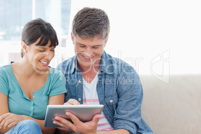 A couple sitting and using a tablet pc together