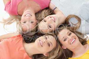 Four girls smiling as they lie on the floor together