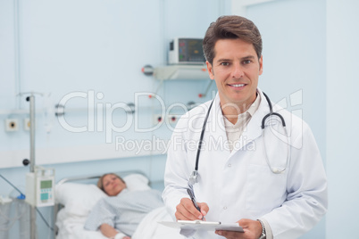 Doctor writing on a chart while smiling