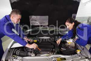 Mechanics looking at a car engine