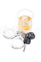 Car key next to a whiskey and a handcuff