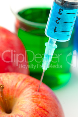 Close up of a syringe injecting liquid into an apple