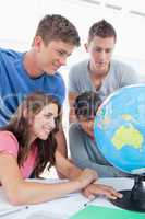Close up of a group of students looking at the globe