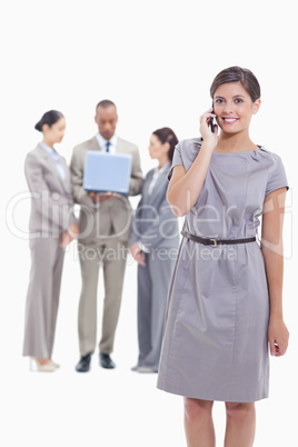 Businesswoman on the phone looking straight ahead with one arm a