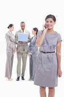 Businesswoman on the phone looking straight ahead with one arm a