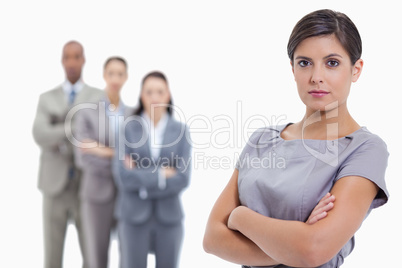 Close-up of a serious businesswoman and a team crossing their ar