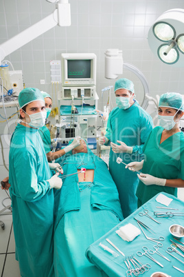 Group of surgeons operating a patient in an operating theater