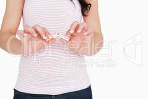 Young pregnant woman breaking a cigarette