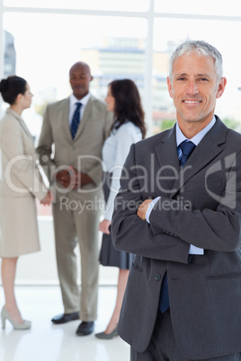 Mature smiling businessman crossing his arms in front of his col