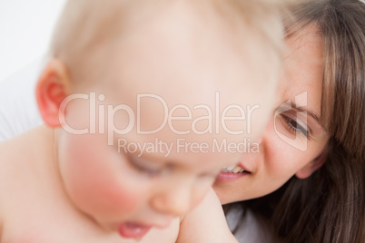 Smiling mother looking at her cute little daughter