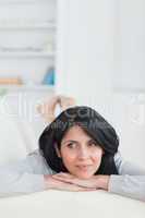 Woman relaxing on a couch holding her head with two hands