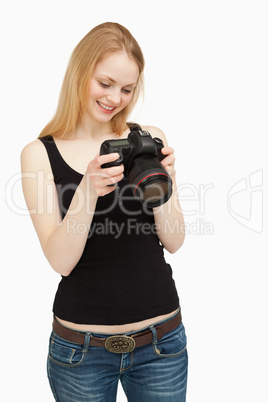 Woman looking at the screen of her camera while smiling