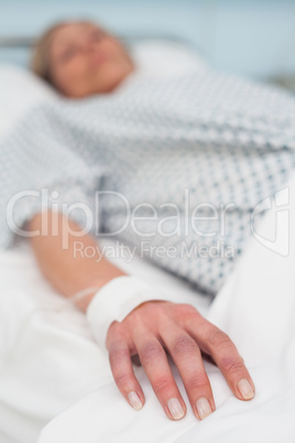 Focus on the hand of a patient lied on a bed
