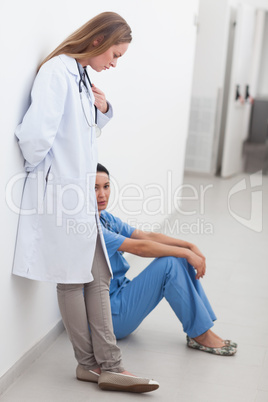 Doctor standing next to a nurse sitting on the floor