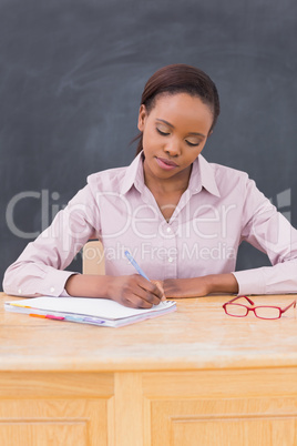 Teacher writing at her desk