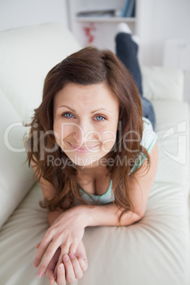 Smiling woman lying on the belly on a sofa