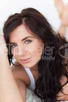 Peaceful brunette woman lying on her bed