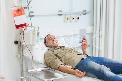 Smiling transfused patient looking at a tablet computer