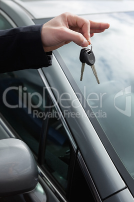 Someone holding car keys by his fingertips