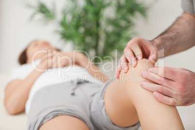 Knee of a woman being touched by a doctor