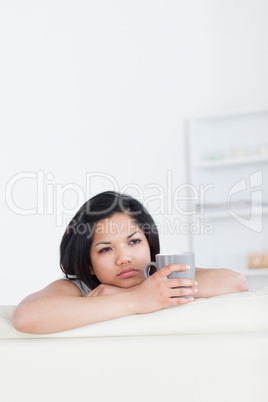 Woman relaxing on a sofa while holding a mug