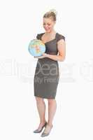 Businesswoman looking at globe in her hands