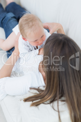 Mother lying on a sofa with a baby on her chest