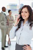 Smiling businesswoman talking on the phone with one hand on her