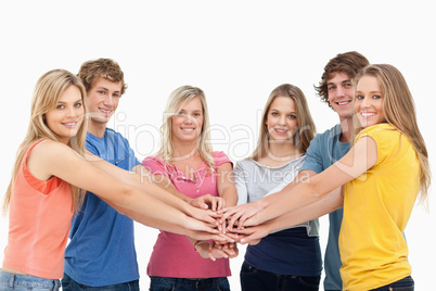 Friends standing around each other as they stack their hands