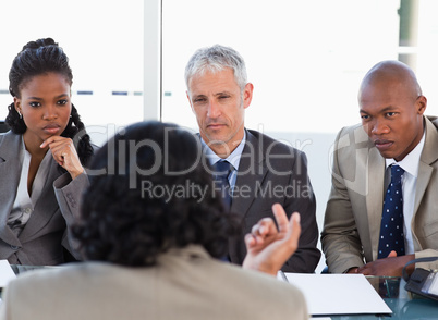Three business people attentively listening to a speaker in a me
