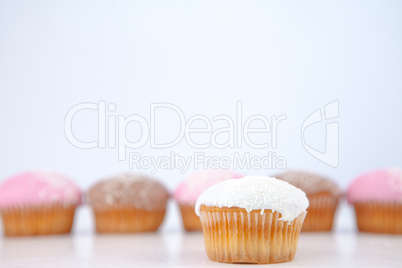 Muffin placed in front of a line of muffin with icing sugar