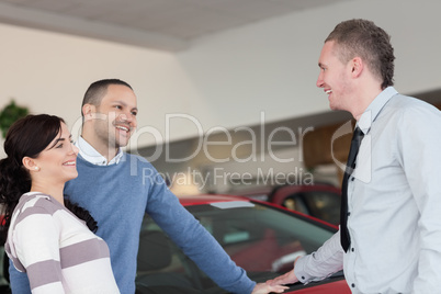 Laughing couple talking with a salesman