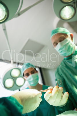 Close up of a scissors being given to a surgeon