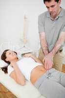 Physiotherapist touching the abdomen of a woman