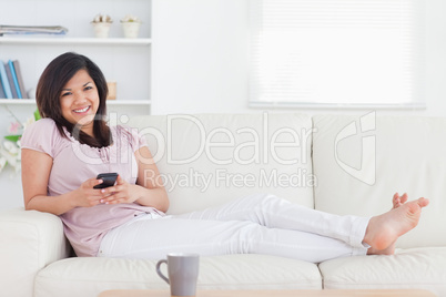 Woman smiling and lying on a couch Woman smiling and lying on a couch