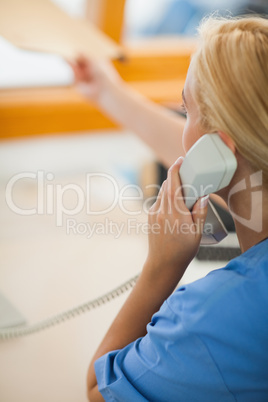 Nurse holding a phone and giving a folder