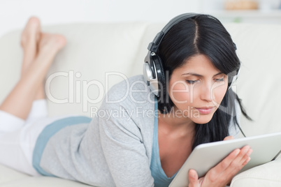 Woman wearing headphones and holding a tablet