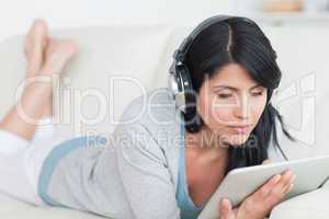 Woman wearing headphones and holding a tablet