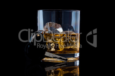 Tumbler glass with whiskey and a car key