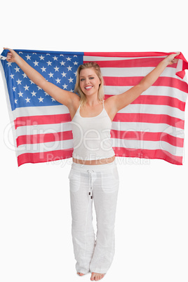 Cheerful blonde woman raising the American flag