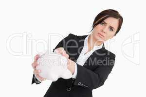 Upset businesswoman holding an empty piggy bank