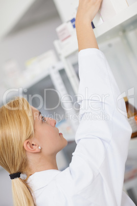 Blonde pharmacist taking a drug box