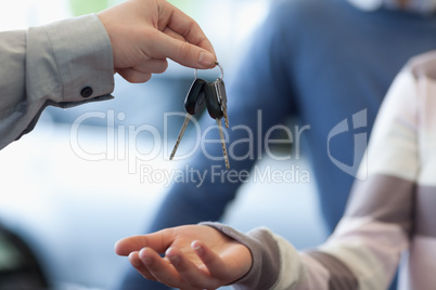 Car dealer giving keys to a customer