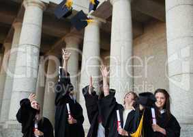 Happy graduates throwing their hats in the sky